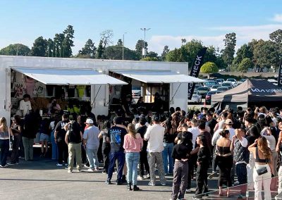 Customers line up to purchase merch from a CW Trailer