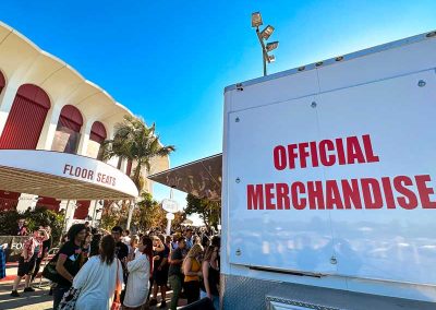 Customers line up to purchase merch from a CW Trailer at the Kia Forum